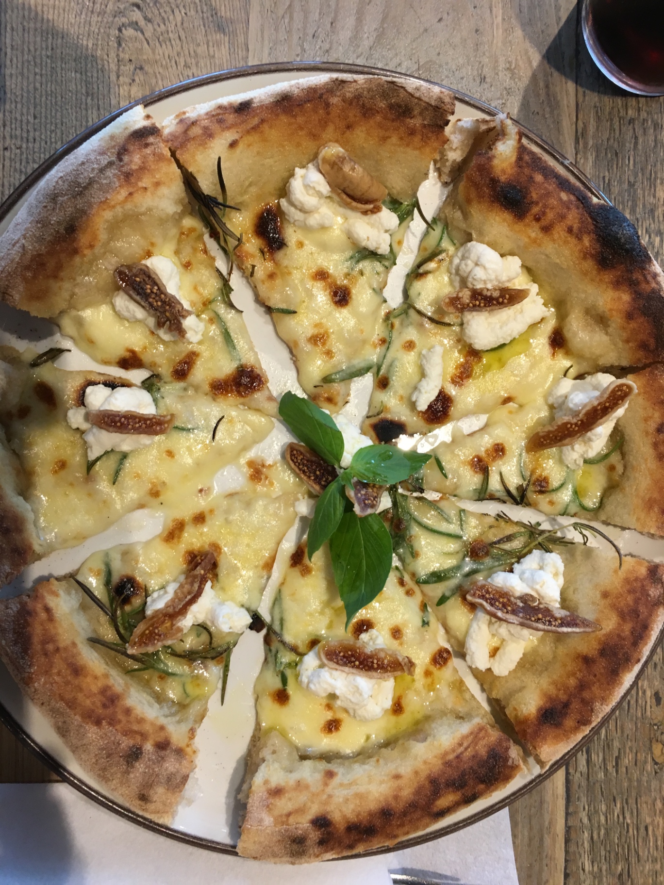Nybakt pizza med ricotta, fiken og rosmarin på et lokalt spisested